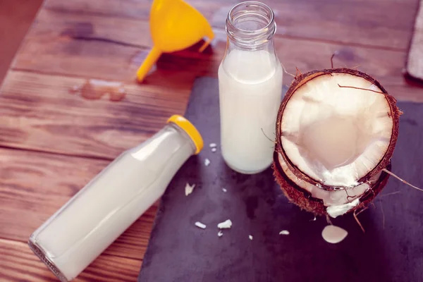 깔때기가 코코넛 반쪽과 배경에 우유가 — 스톡 사진