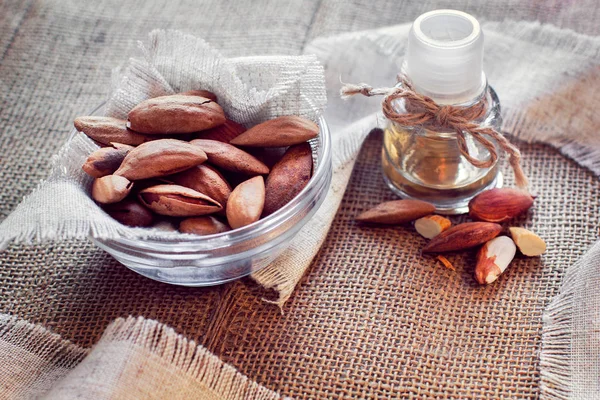 bir badem'ın yağı ve badem bir çul üzerinde bir cam daire içinde şişeyle