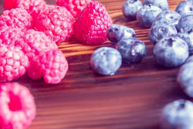 Ahududu ve ahşap arka plan üzerinde yaban mersini