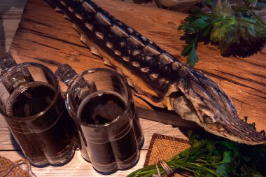 karanlık bira ve Yeşiller ahşap arka plan üzerinde kurutulmuş mersin balığı