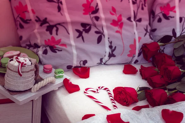 舒适的生活在床上的早餐为情人节 在一张有两个枕头的床上放着咖啡和饼干 红玫瑰 花瓣散落在床上 上面有两个枕头和条纹棒棒糖的心 — 图库照片
