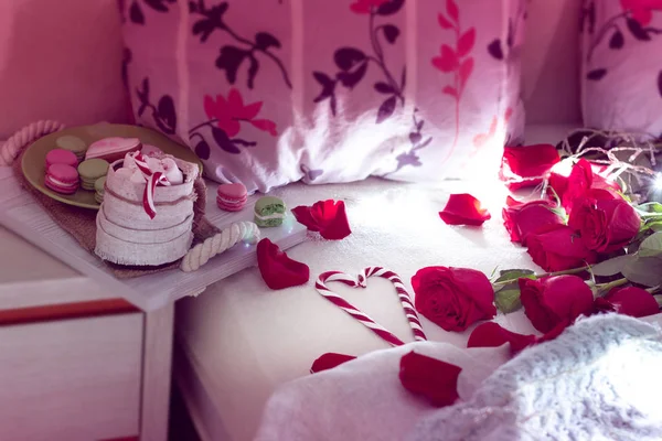 舒适的生活在床上的早餐为情人节 在一张有两个枕头的床上放着咖啡和饼干 红玫瑰 花瓣散落在床上 上面有两个枕头和条纹棒棒糖的心 — 图库照片