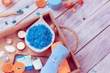 Spa oluşur havlu, mavi deniz tuzu, mumlar ve mandalina içinde ahşap tepsi
