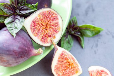 incir fesleğen ile karanlık bir arka plan üzerinde yeşil kase dilimlenmiş