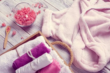 Spa oluşur bornoz, ufalanmış pembe deniz tuzu ve havlu içinde ahşap tepsi