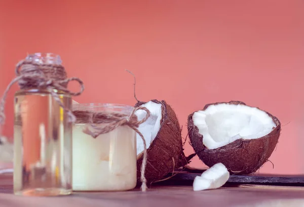 Zwei Hälften Kokos Und Kokosöl Flaschen Auf Korallengrund — Stockfoto