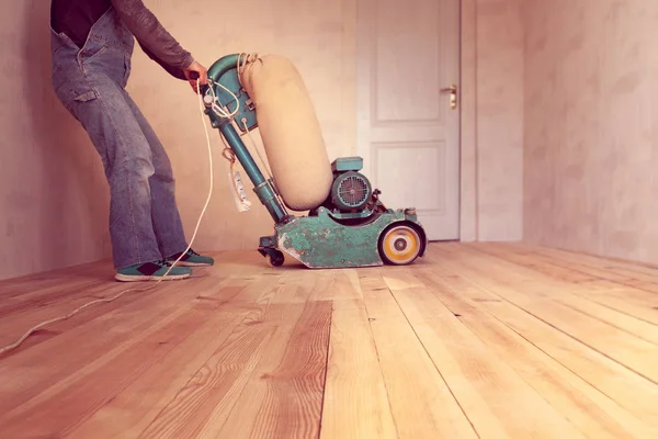 Carpenter works by electric grinding wood machine in a room — Stock Image Carpenter works by electric grinding wood machine in a room Stock Image