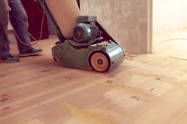 Carpenter works by electric grinding wood machine in a room — Stock Image Carpenter works by electric grinding wood machine in a room Royalty Free Stock Photos