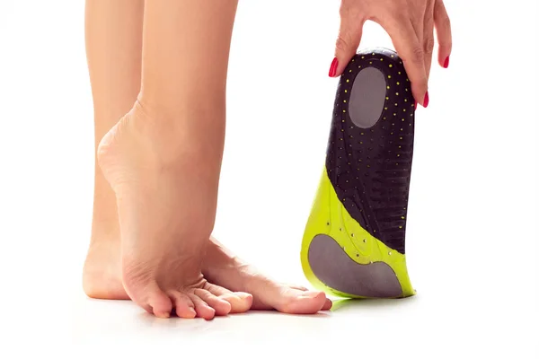 Vrouwelijke voeten en orthopedische inlegzool — Stockfoto