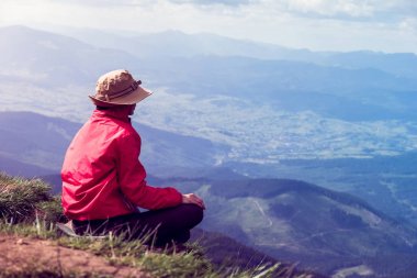 kadın oturur ve Uzaktan dağlara arıyorsunuz