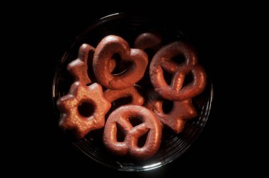 Çeşitli şekillerde çikolata kurabiye dolu siyah kase