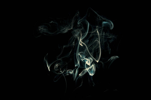 Many curly thin wisps of smoke isolated on a black background