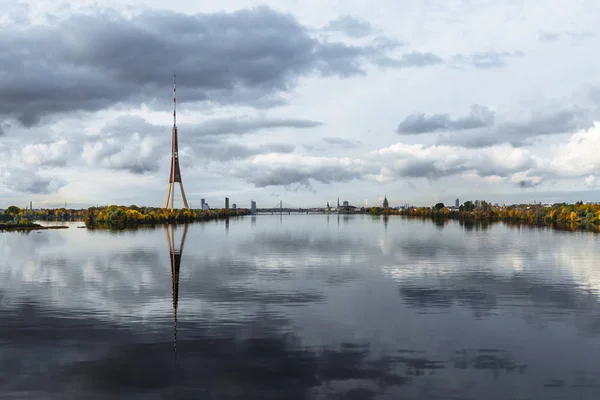 Ciudad Riga, Letonia. Torre de TV en Capital. Gran edificio en el centro de la ciudad. Foto de viaje - Hermoso río azul Daugava con cielo claro y nubes — Foto de Stock
