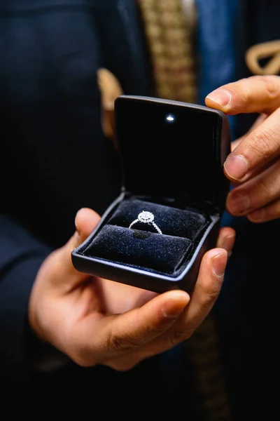 Propuesta de la vida real: El hombre sostiene un anillo de compromiso iluminado - Anillo de novia azul con una gran joya — Foto de Stock