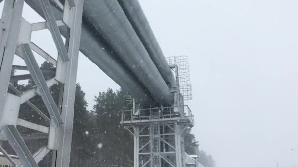Riga, ラトビアの雪に覆われた通りに沿って敷設された 4 k の巨大なガスのパイプライン — ストック動画