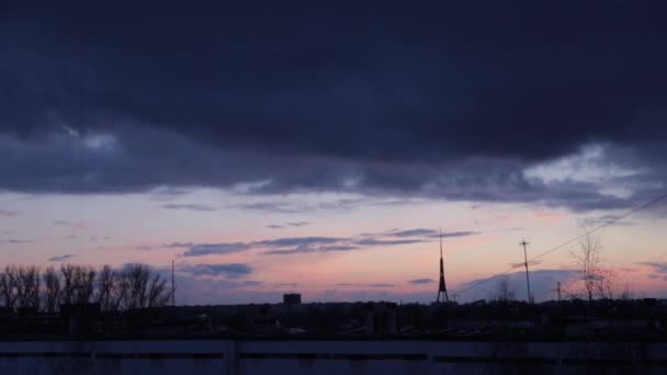 Panoráma města s nádherný pestrobarevný zářivé svítání. Úžasné dramatické modrá obloha s lila a fialové mraky nad temné siluety města budov. — Stock video