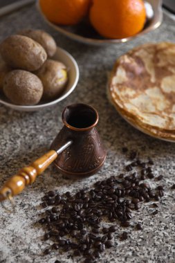 Cezve kahve çekirdekleri ve arka planda haşlanmış patates ile pancakes ile
