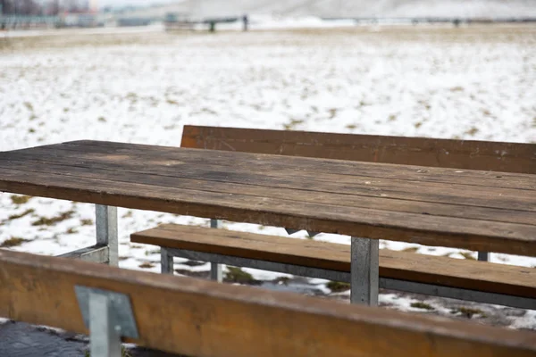 Mesa de madeira vazia com bokeh de neve para um fundo de catering ou comida — Fotografia de Stock