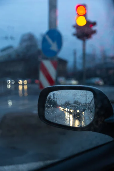 Engarrafamento noturno no espelho retrovisor lateral com semáforos vermelhos e amarelos — Fotografia de Stock