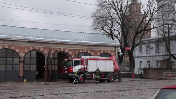 RIGA, LATVIA - 16 DE MARZO DE 2019: Se está limpiando el camión de bomberos - El conductor lava el camión de bomberos en un depósito - Vista panorámica — Vídeo de stock