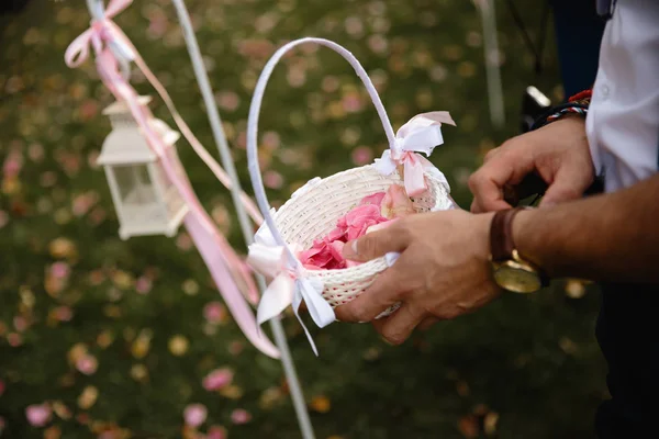 Мужчина в золотых часах, готовящийся бросать лепестки - Свадебное оформление во время приема - Нежный розовый и белый цвет - Открытый — стоковое фото