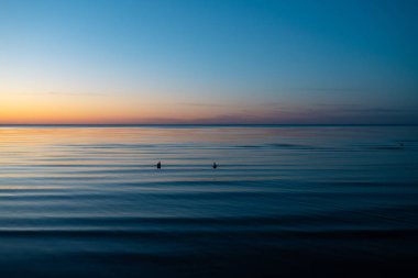 Baltık Devletleri - canlı şaşırtıcı günbatımı güneş tarafından deniz horizon ile alacakaranlıkta aydınlatır
