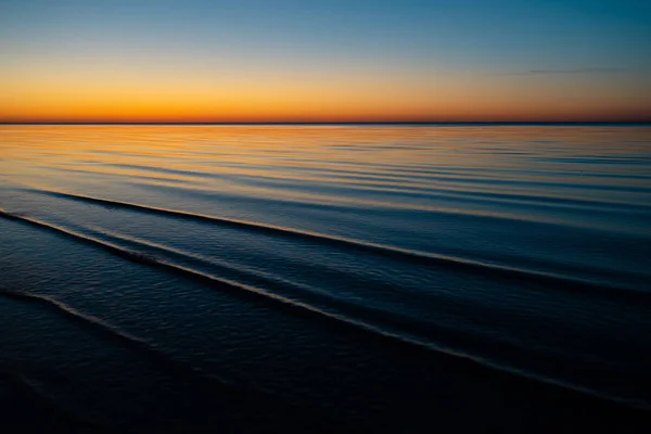 Vivid increíble puesta de sol en los Estados Bálticos - Atardecer en el mar con horizonte se ilumina por el sol — Foto de Stock