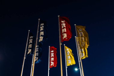 Riga, Letonya-3 Nisan 2019: IKEA bayrakları karanlık akşam ve rüzgar sırasında-arka planda mavi gökyüzü