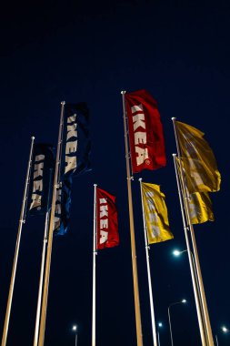 Riga, Letonya-3 Nisan 2019: IKEA bayrakları karanlık akşam ve rüzgar sırasında-arka planda mavi gökyüzü