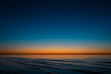 Baltık Devletleri - canlı şaşırtıcı günbatımı güneş tarafından deniz horizon ile alacakaranlıkta aydınlatır
