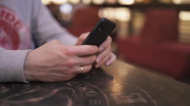 Молодой бизнесмен, сидящий за столом в кафе с помощью iphone и набирающий сообщение - Успешные люди, повседневная рутина — стоковое видео