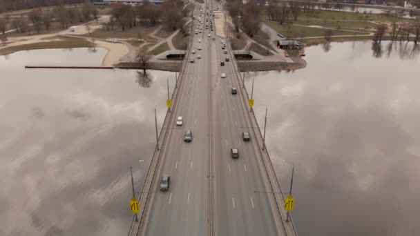 Vista aérea da Ponte da Ilha em Riga - Clima sombrio - Voo sobre o rio Daugava com nuvens refletindo na água — Vídeo de Stock