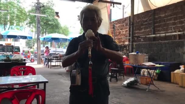 KO CHANG, THAILAND - APRIL 9, 2018: Man playing flute at a cheap thay restaurant terrace — Stock Video