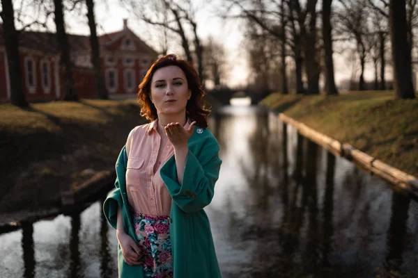 Güzel genç kadın Rundale, Letonya, 2019 Saray yakınlarındaki bir parkta bir kanal Nehri yakınında rahatlatıcı