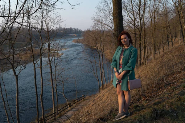 Mladá módní žena relaxační a užívající si Západ slunce u řeky v Bausce, Lotyšsko, 2019 — Stock fotografie