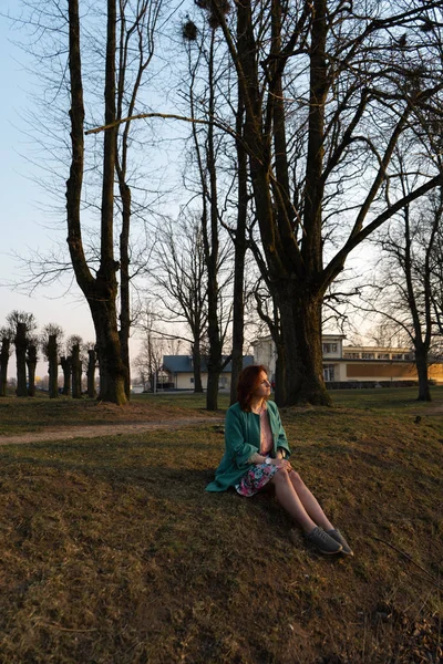 Mujer de moda joven relajándose y disfrutando de la puesta de sol cerca de un río en Bauska, Letonia, 2019 —  Fotos de Stock