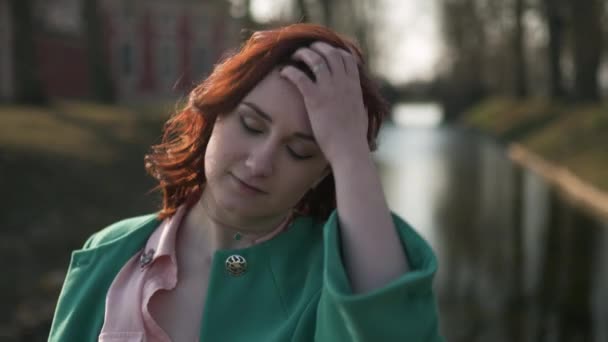 Portret close up face-jonge vrouw ontspannen in de buurt van een paleis deel kanaal tijdens een warme lente weer dragen van groene mode jas-Redhead — Stockvideo