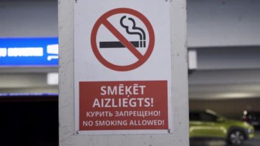 Bir alışveriş merkezinde Ingilizce, Rusça ve Letonca sigara içme işareti yok