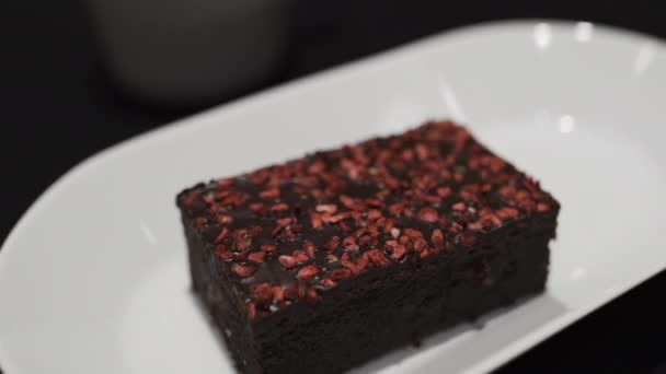 Välsmakande söt brownet i ett kafé-röd hallon ovanpå — Stockvideo