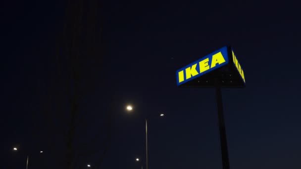 RIGA, LATVIA - 3 DE ABRIL DE 2019: Señal de la marca IKEA durante la noche oscura y el viento - Cielo azul en el fondo — Vídeo de stock