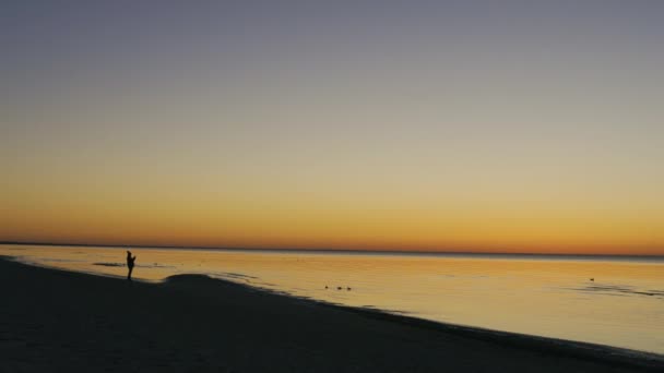 Mujer joven tomando fotos y fotografiando - Hermosa puesta de sol vívida en Jurmala, Bulduri, Letonia 2019 - Coloridos colores brillantes amarillo azul y violeta — Vídeo de stock