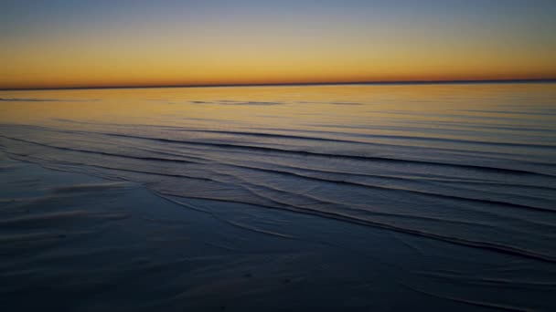 Profundidad de campo poco profunda que muestra las olas - Hermosa puesta de sol vívida en Jurmala, Bulduri, Letonia 2019 - Coloridos colores brillantes amarillo azul y violeta — Vídeo de stock