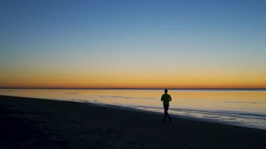 Lone Evening Runner spor yapıyor-Jurmala güzel canlı günbatımı, Bulduri, Letonya 2019-renkli parlak renkler sarı mavi ve menekşe