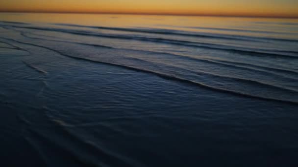 Profundidad de campo poco profunda que muestra las olas - Hermosa puesta de sol vívida en Jurmala, Bulduri, Letonia 2019 - Coloridos colores brillantes amarillo azul y violeta — Vídeo de stock