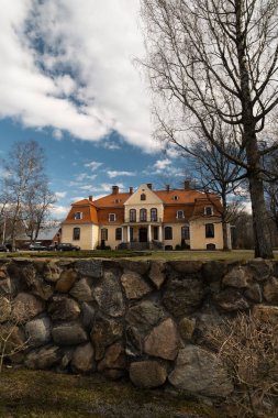 Liepupe, Letonya-13 Nisan 2019: mavi gökyüzü ve bulutlar ile güzel güneşli bahar havalarda Liepupes Muiza malikanesi