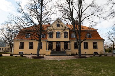 Liepupe, Letonya-13 Nisan 2019: mavi gökyüzü ve bulutlar ile güzel güneşli bahar havalarda Liepupes Muiza malikanesi