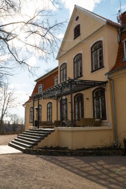 Liepupe, Letonya-13 Nisan 2019: mavi gökyüzü ve bulutlar ile güzel güneşli bahar havalarda Liepupes Muiza malikanesi