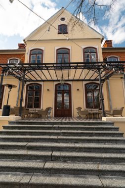 Liepupe, Letonya-13 Nisan 2019: mavi gökyüzü ve bulutlar ile güzel güneşli bahar havalarda Liepupes Muiza malikanesi