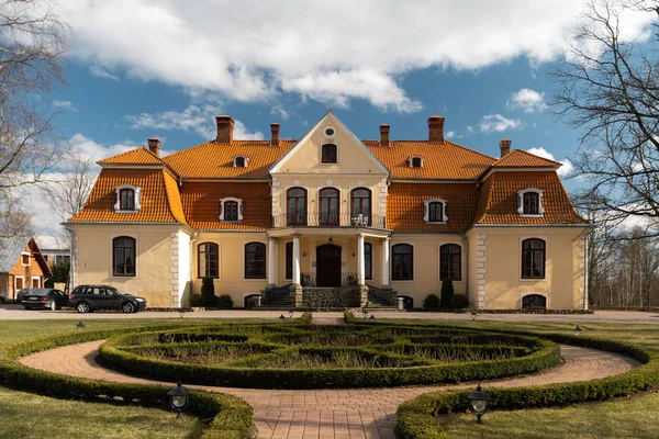 LIEPUPE, LATVIA - 13 de abril de 2019: Liepupes Muiza mansão em belo tempo ensolarado Primavera com céu azul e nuvens — Fotografia de Stock