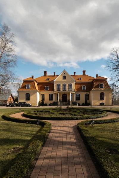 LIEPUPE, LATVIA - 13 de abril de 2019: Liepupes Muiza mansão em belo tempo ensolarado Primavera com céu azul e nuvens — Fotografia de Stock